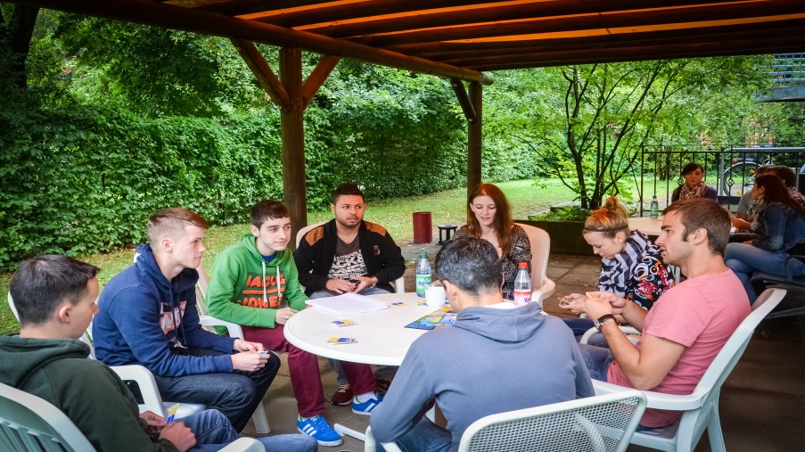 Jugendliche auf der Terrasse der Station, Karten spielend.