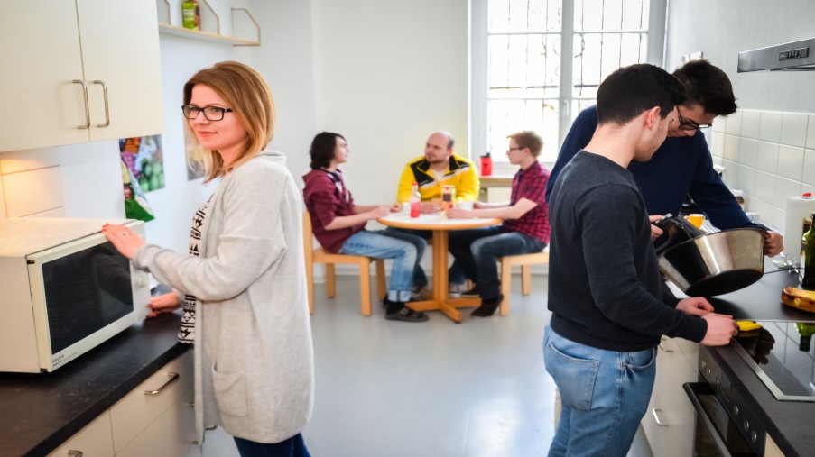 Jugendliche in der Stationsküche, teils arbeitend, teils am Tisch sitzend