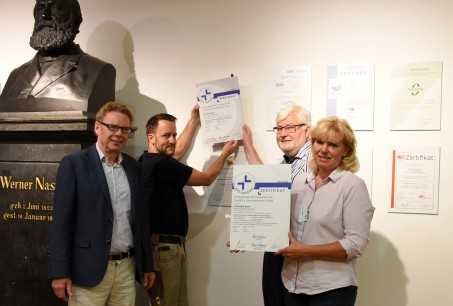 Der Klinikvorstand (Michael van Brederode, Prof. Dr. Markus Banger und Elvira Lange) tauschen das aktuell erworbene KTQ-Zertifikat gegen das abgelaufene aus. Unterstützt von Mitarbeiter Ralf Schömer.